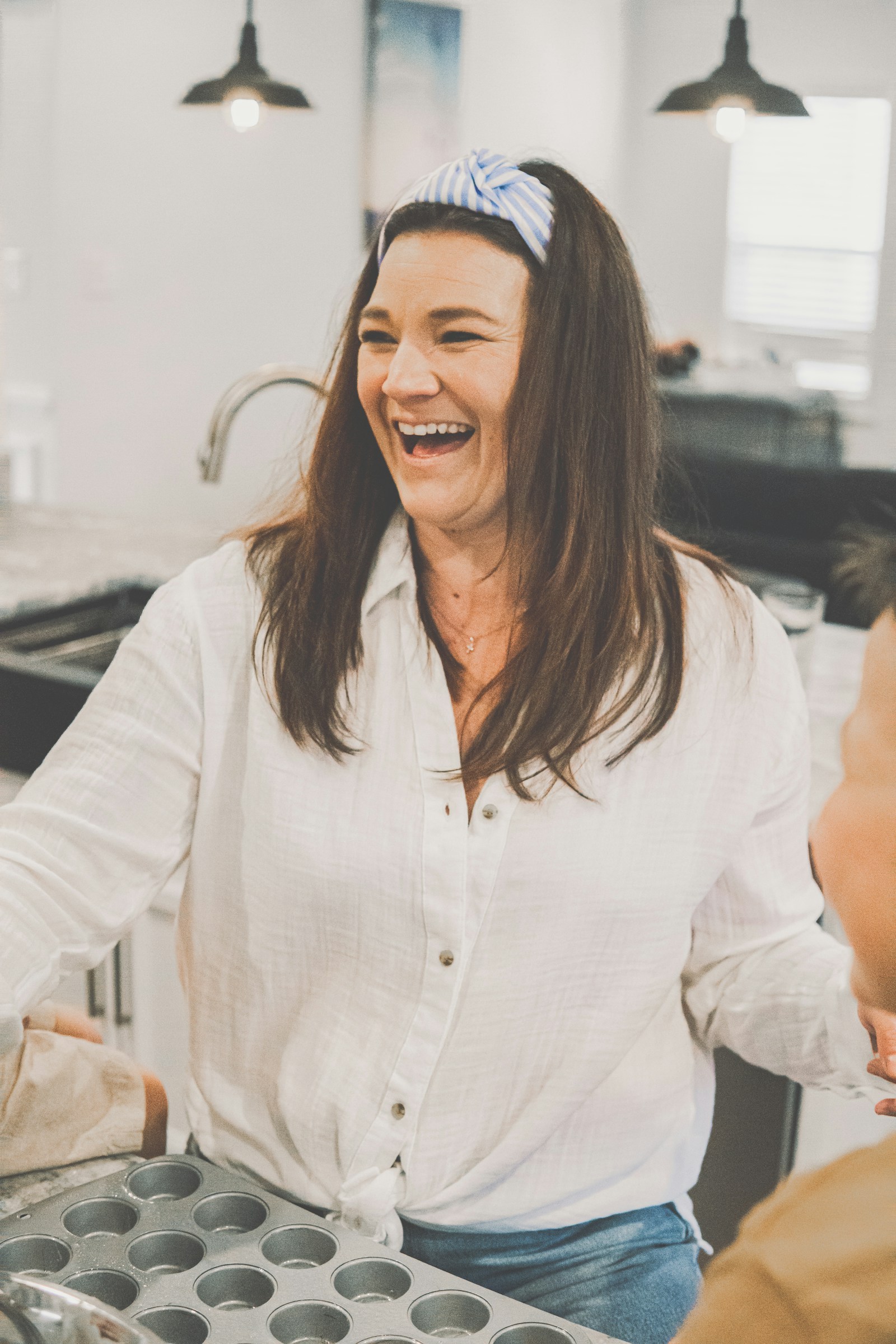 Smiling homeowner in her bright new white kitchen